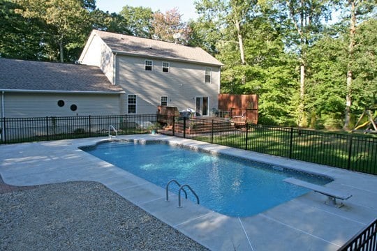 This Is A Photo Of A Patrician In Ground Pool In Montville, CT With Diving Board And Black Fence.