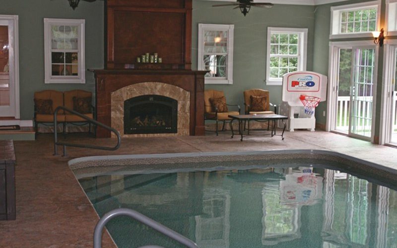 This Is A Photo Of A Custom Rectangular Inground Swimming Pool Indoors With Rounded Corners And Fireplace