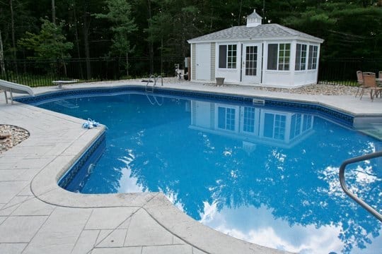 This Is A Photo Of A Lazy L Style Custom Inground Swimming Pool With A Custom Pool House And Water Slide.