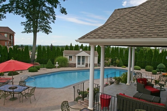 This is a photo of The Lazy-L in ground pool in Somers, CT with custom pavers and steps.