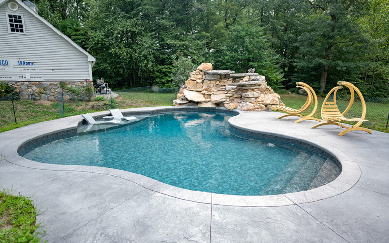 Custom Swimming Pool Built By Juliano's Pools With Swim-out And Stamped Concrete Patio